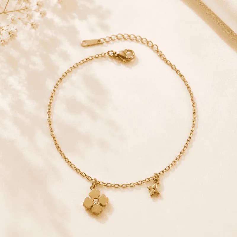 Cable chain anklet in gold tone with a four-leaf clover charm set with a clear stone